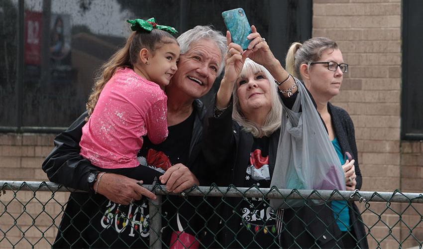 A little girl taking a selfie with her grandparents