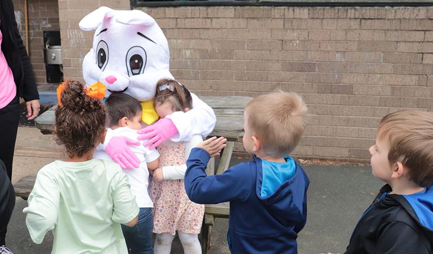 Kids hugging Mr. Bunny.